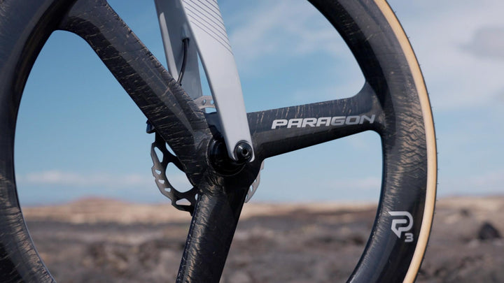 Bicycle wheel with 'Paragon' branding against a blurred natural background